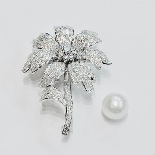 Broche flor en oro blanco con 235 diamantes en total 4,60 quilates, con centro desmontable y sustituible por una perla australiana. Consultar precio.